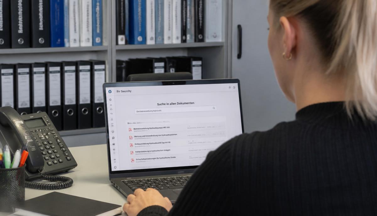 Mitarbeiterin sucht am Notebook in internen Dokumenten und Handbüchern